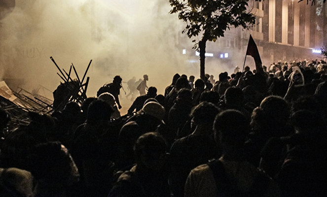 Протестующие во время столкновения с сотрудниками полиции в районе Бешикташ возле площади Таксим в Стамбуле.